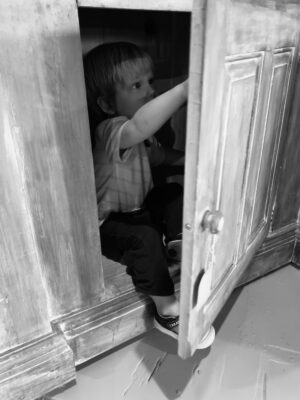 James playing in the antique cupboard in the antique shop