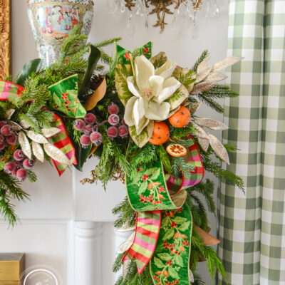 Glittered magnolia and laurel sparkle on this 2026 Christmas garland idea that blends traditional Colonial Williamsburg style with that Old World Christmas feel.