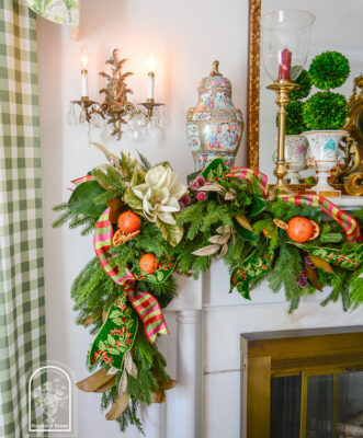 Glittered magnolia and laurel sparkle on this 2026 Christmas garland idea that blends traditional Colonial Williamsburg style with that Old World Christmas feel.