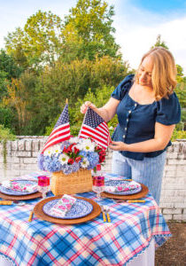 Katherine fixes American flag in floral centerpiece for Independence Day table