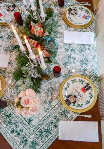 Top view of elegant winter themed Christmas tablescape in green and white with hints of red and pink