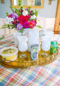 Ingredients for a pineapple sherbet limeade mocktail on vintage brass tray with plaid tablecloth