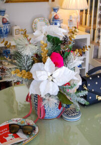 Front entry table with white poinsettia floral arrangement in blue and white ginger jar
