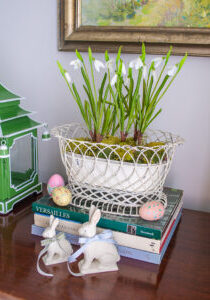 Vintage decor for a taste of spring: white wire basket filled with faux snowdrops, porcelain bunnies, and painted easter eggs adorn this sideboard