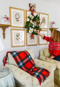 Festive touches to add to your Christmas decorating that make your house feel more merry! Katherine adjusts a magnolia wreath hung over her botanical gallery wall.