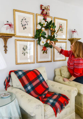 Festive touches to add to your Christmas decorating that make your house feel more merry! Katherine adjusts a magnolia wreath hung over her botanical gallery wall.