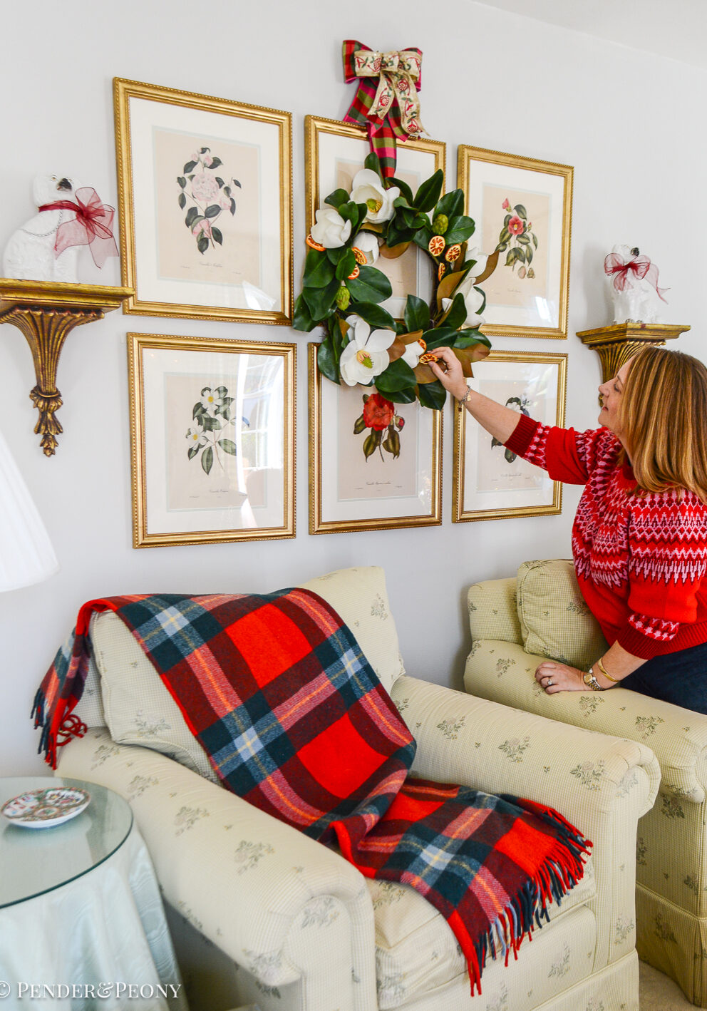 Festive touches to add to your Christmas decorating that make your house feel more merry! Katherine adjusts a magnolia wreath hung over her botanical gallery wall.