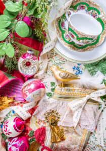 Grandmillennial Southern Christmas inspiration flat lay with plaid ribbon, magnolia, vintage baubles, and Althea Hollyhock Lee Jofa fabric