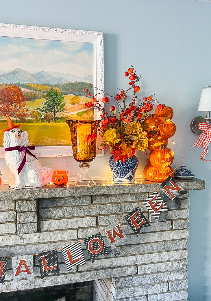 My festive Halloween mantel with a witchy Jane aka my Staffordshire spaniel, jack-o-lanterns, and fall florals