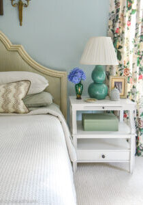 Green and blue master bedroom with white nightstand