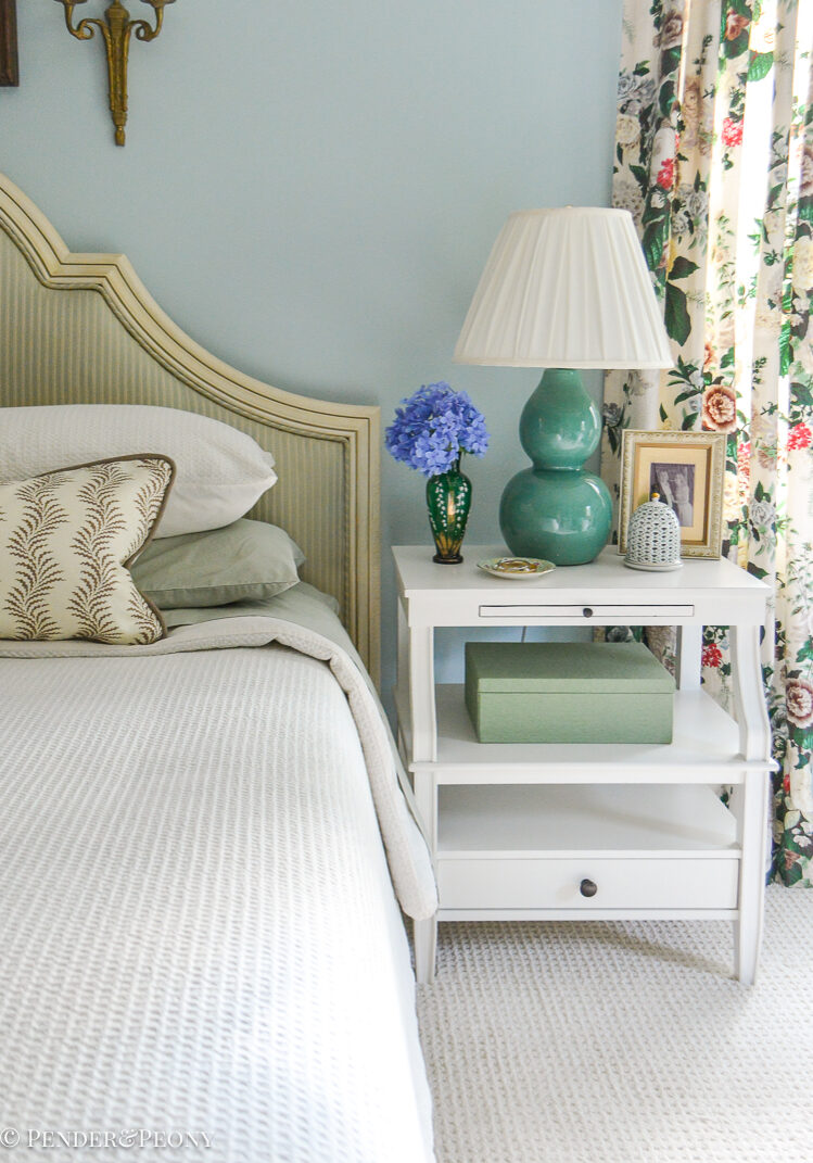 Green and blue master bedroom with white nightstand