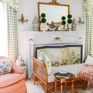 Katherine's collected living room with traditional columned mantel, French gilt mirror, Rose Medallion, and wicker daybed