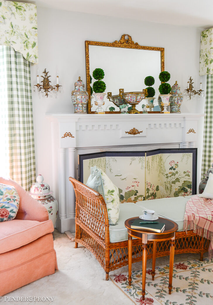 Katherine's collected living room with traditional columned mantel, French gilt mirror, Rose Medallion, and wicker daybed