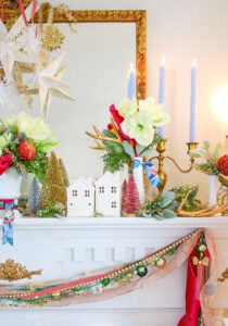 White ceramic houses on this Christmas mantel suggest a snowy winter village