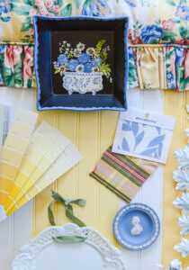Design board for yellow and blue guest bedroom with chintz, floral still life, toleware sconce, yellow paint chips